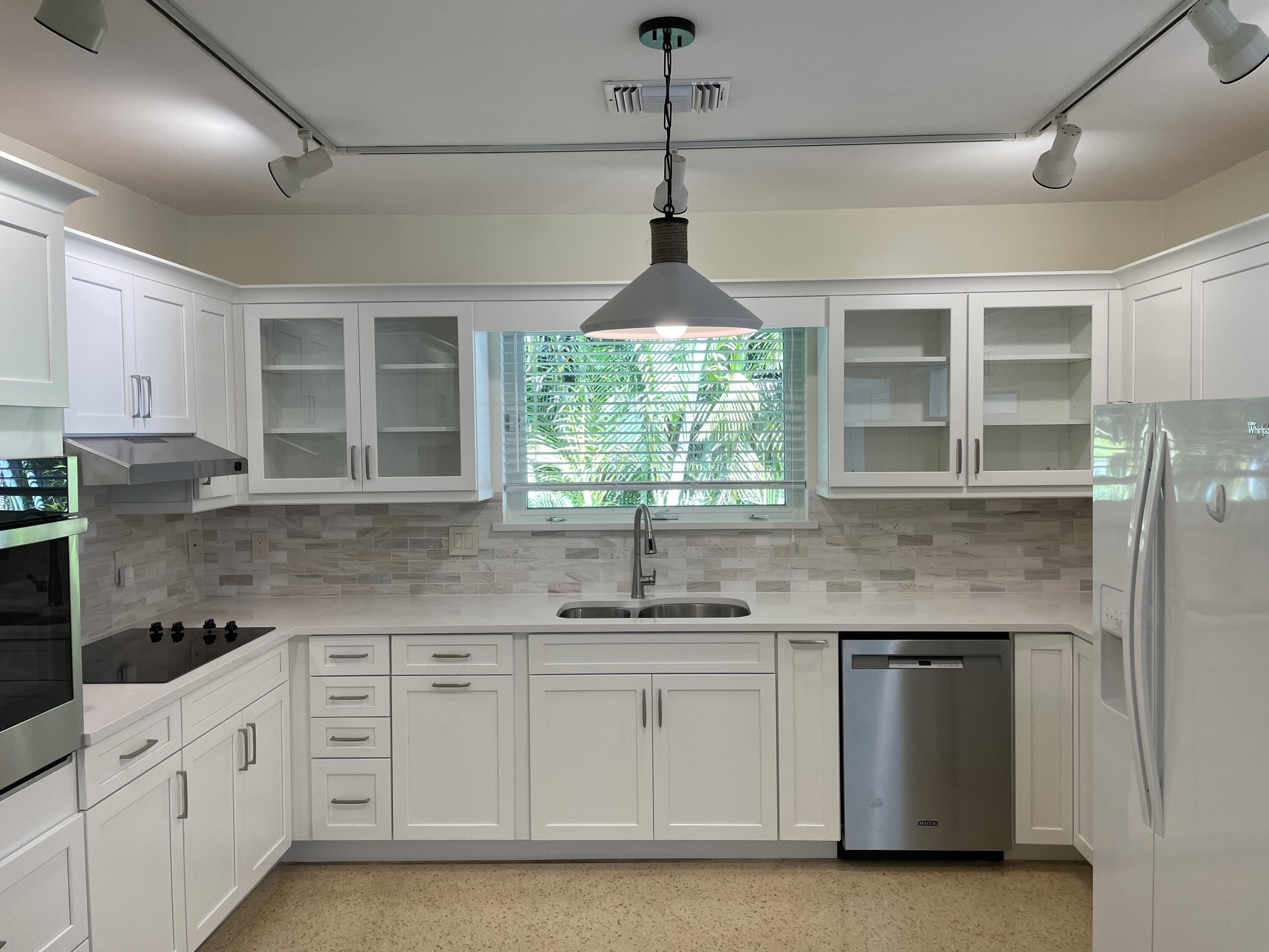 a kitchen with granite countertop white cabinets and window