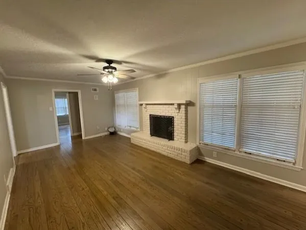 an empty room with wooden floor and fireplace