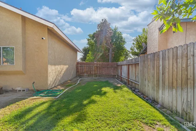 a view of a backyard with wooden fence