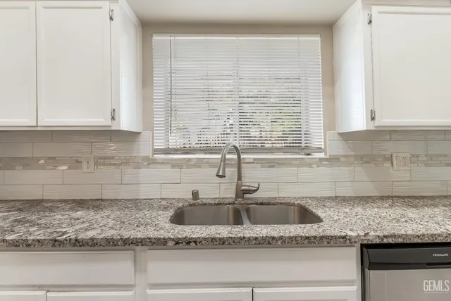 a kitchen with granite countertop a sink and a window