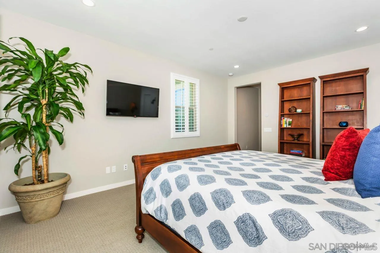 9014 Hightail Drive Santee, CA 92071 - Photo 23 of 45 a bedroom with a bed and a potted plant