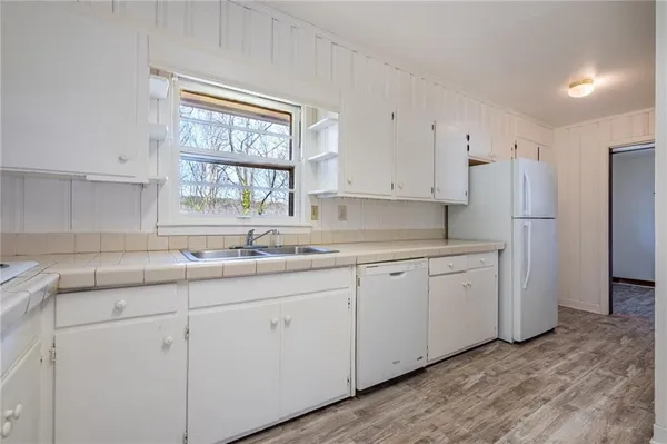 a kitchen with granite countertop white cabinets and white appliances