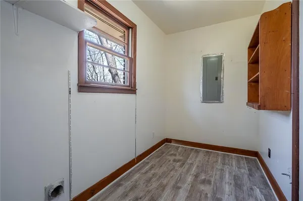 a view of a hallway with wooden floor and a window