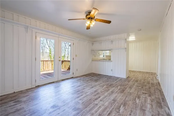a view of an empty room with a window and wooden floor