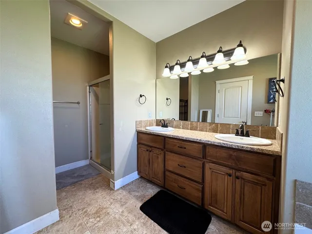 a spacious bathroom with a double vanity sink and a mirror
