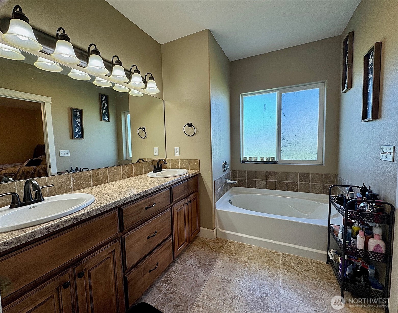 849 South McKinney Road Othello, WA 99344 - Photo 16 of 39 a bathroom with a tub a double vanity sink and a mirror