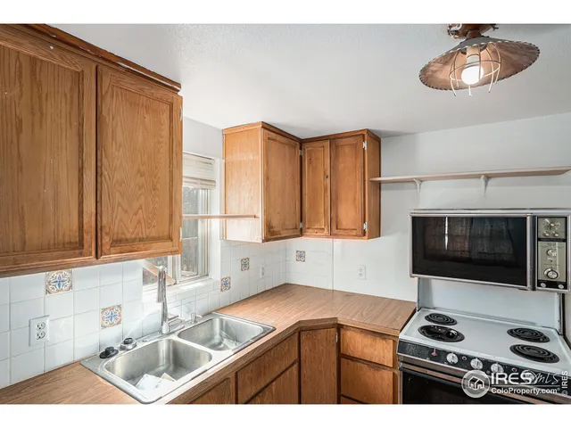 a kitchen with a sink a microwave and cabinets