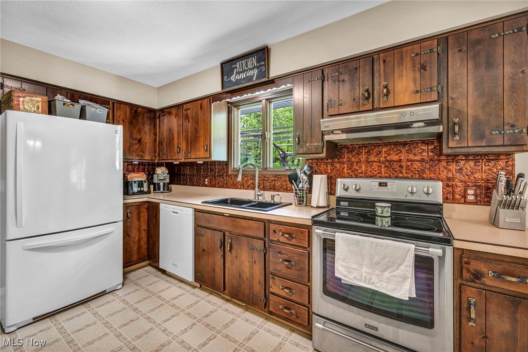 7662 State Road Wadsworth, OH 44281 - Photo 29 of 49 Kitchen featuring white appliances, under cabinet range hood, a sink, and light countertops