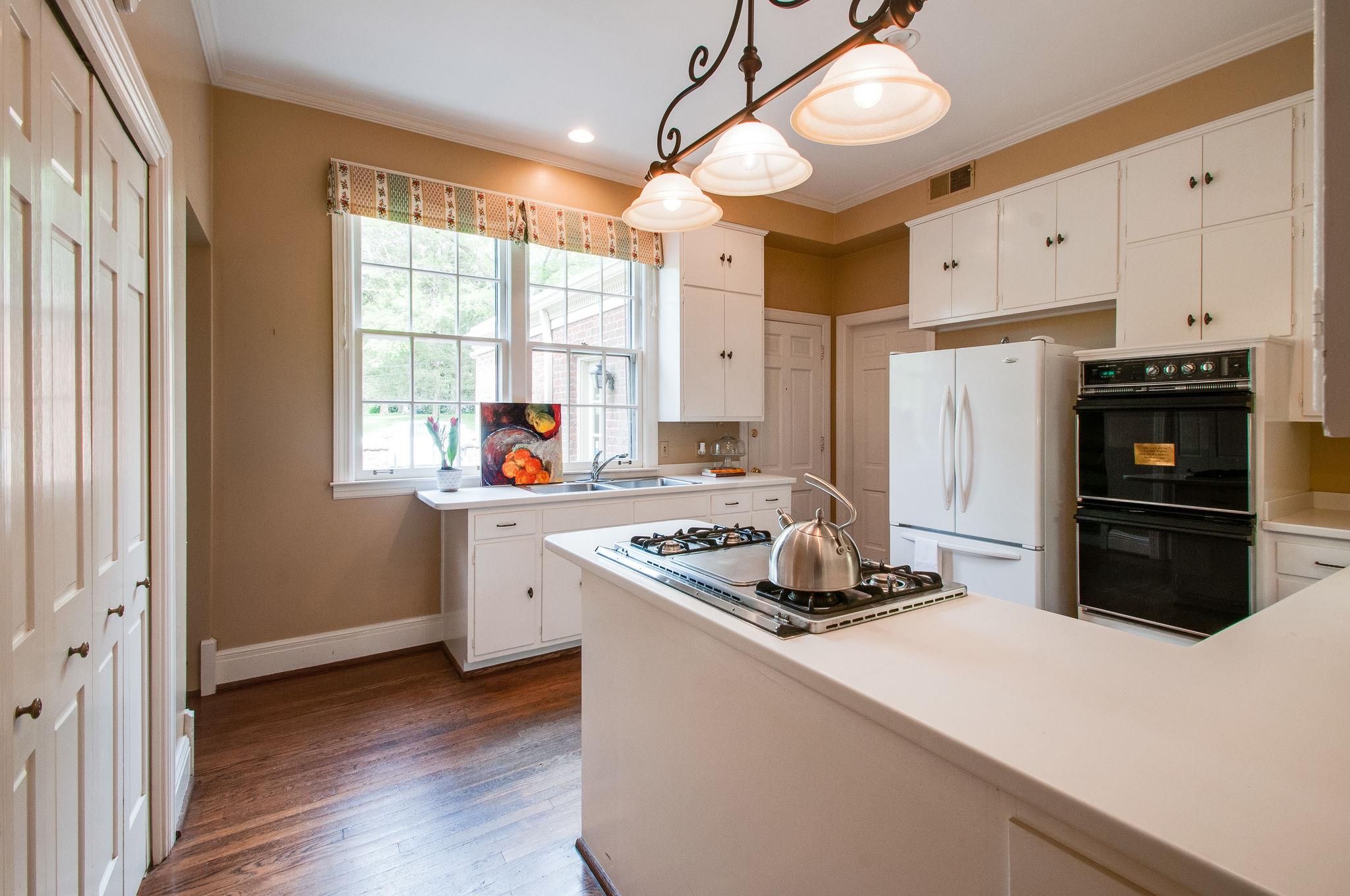4737 Post Road Nashville, TN 37205 - Photo 16 of 30 a kitchen with stainless steel appliances granite countertop a stove a refrigerator and a sink with wooden floor