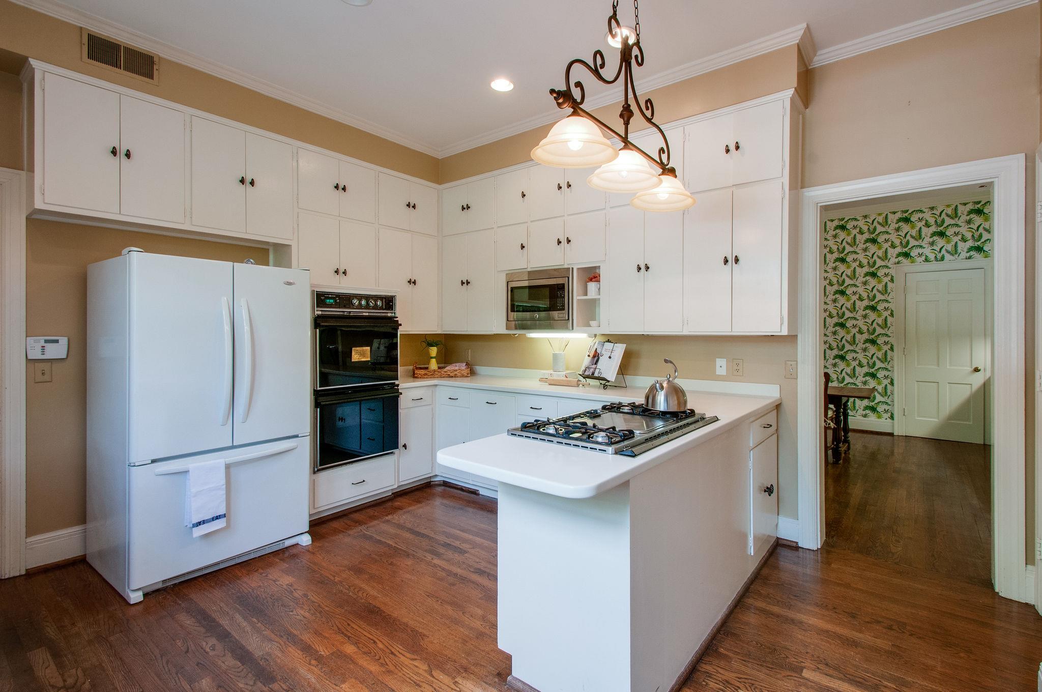 4737 Post Road Nashville, TN 37205 - Photo 17 of 30 a kitchen with stainless steel appliances a stove a refrigerator a sink a stove and white cabinets with wooden floor