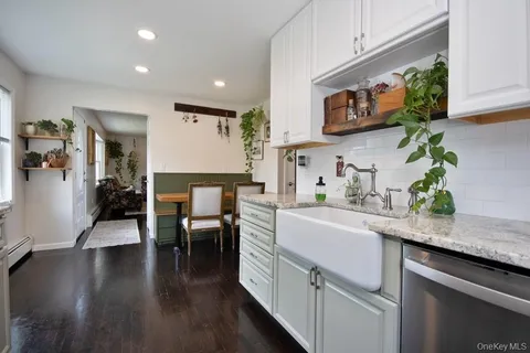 a kitchen with stainless steel appliances a dining table chairs microwave and sink