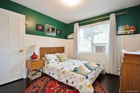 a bedroom with bed and wooden floor