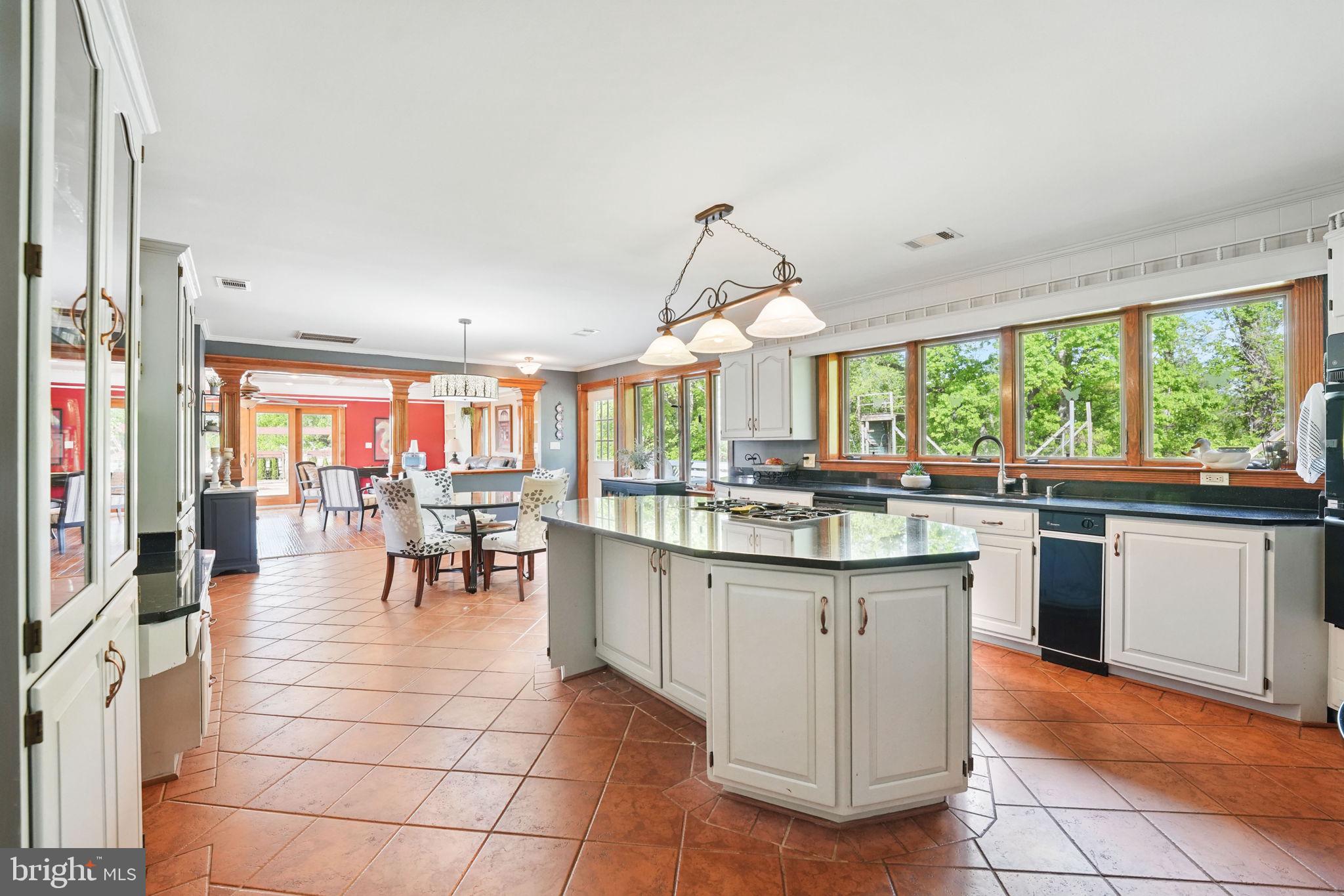 8511 Leeds Manor Road Warrenton, VA 20186 - Photo 17 of 36 a kitchen with granite countertop a table chairs sink and cabinets