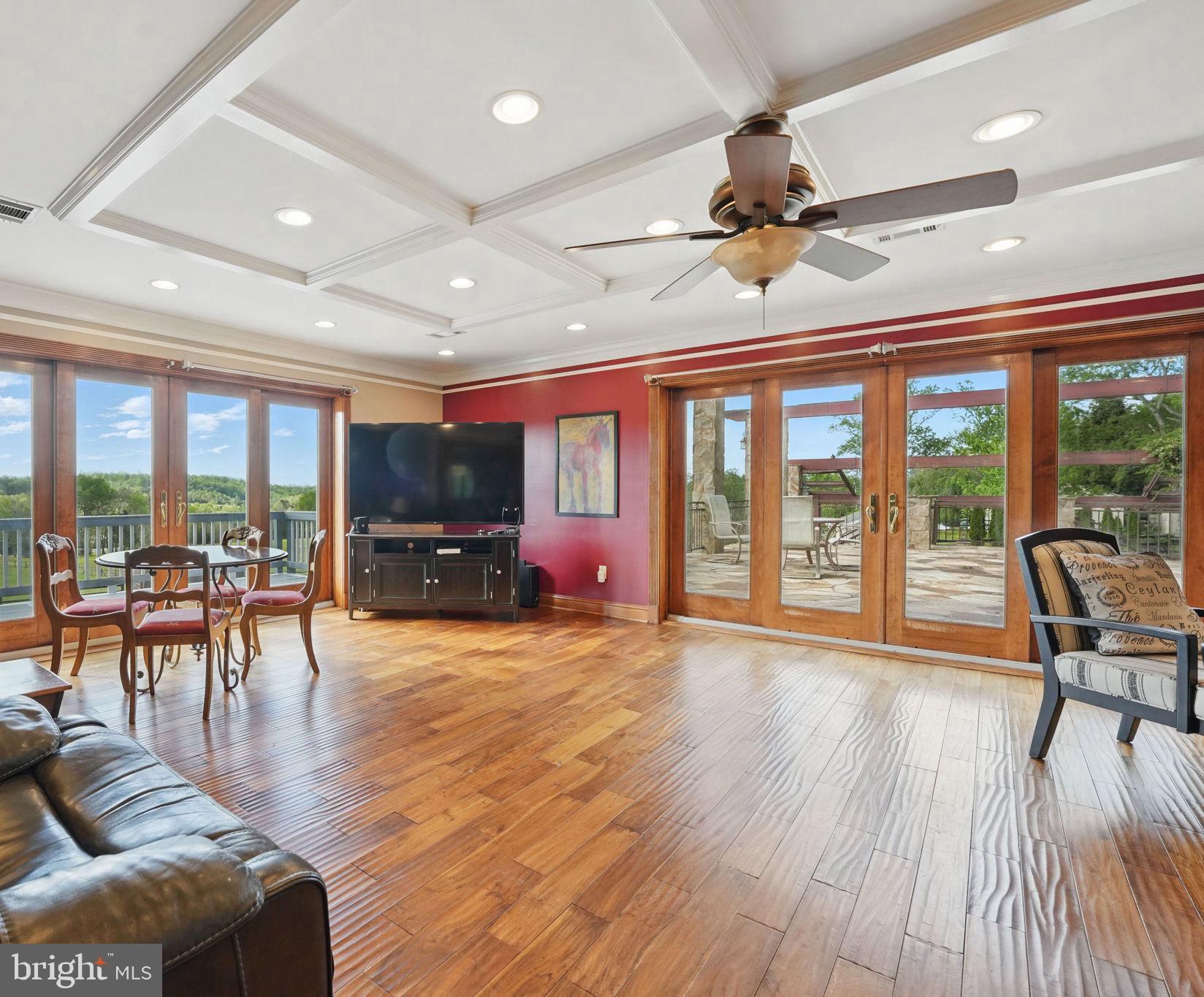 8511 Leeds Manor Road Warrenton, VA 20186 - Photo 20 of 36 a living room with furniture a flat screen tv and floor to ceiling windows