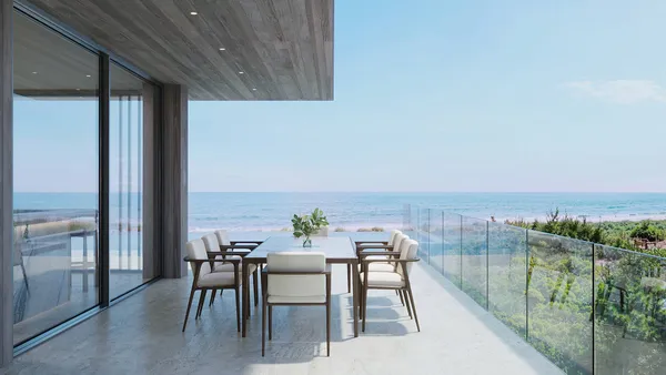 a living room with furniture large windows and view of dining hall with wooden floor