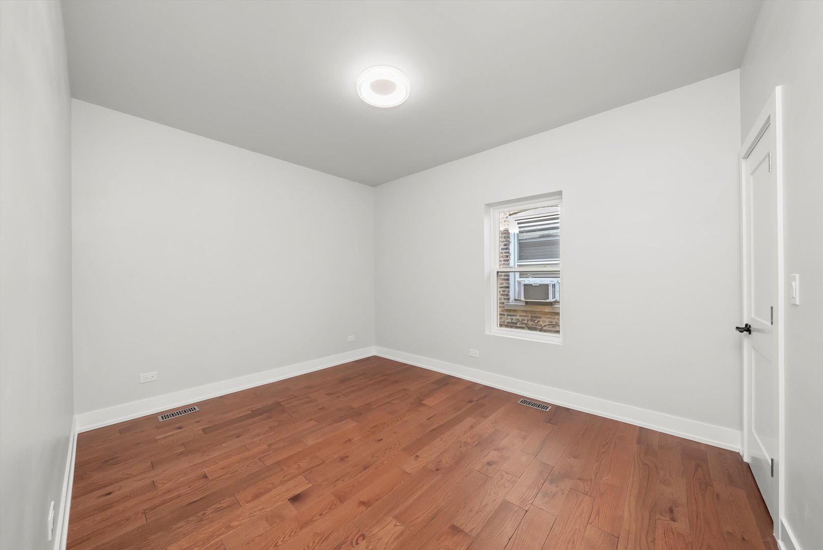 1631 North Parkside Avenue Chicago, IL 60639 - Photo 14 of 33 a view of an empty room with wooden floor and a window