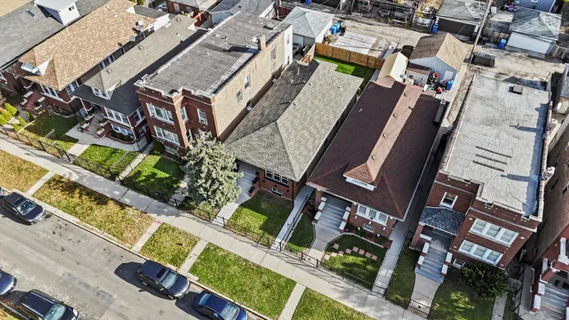 a view of a brick house with a small yard and plants