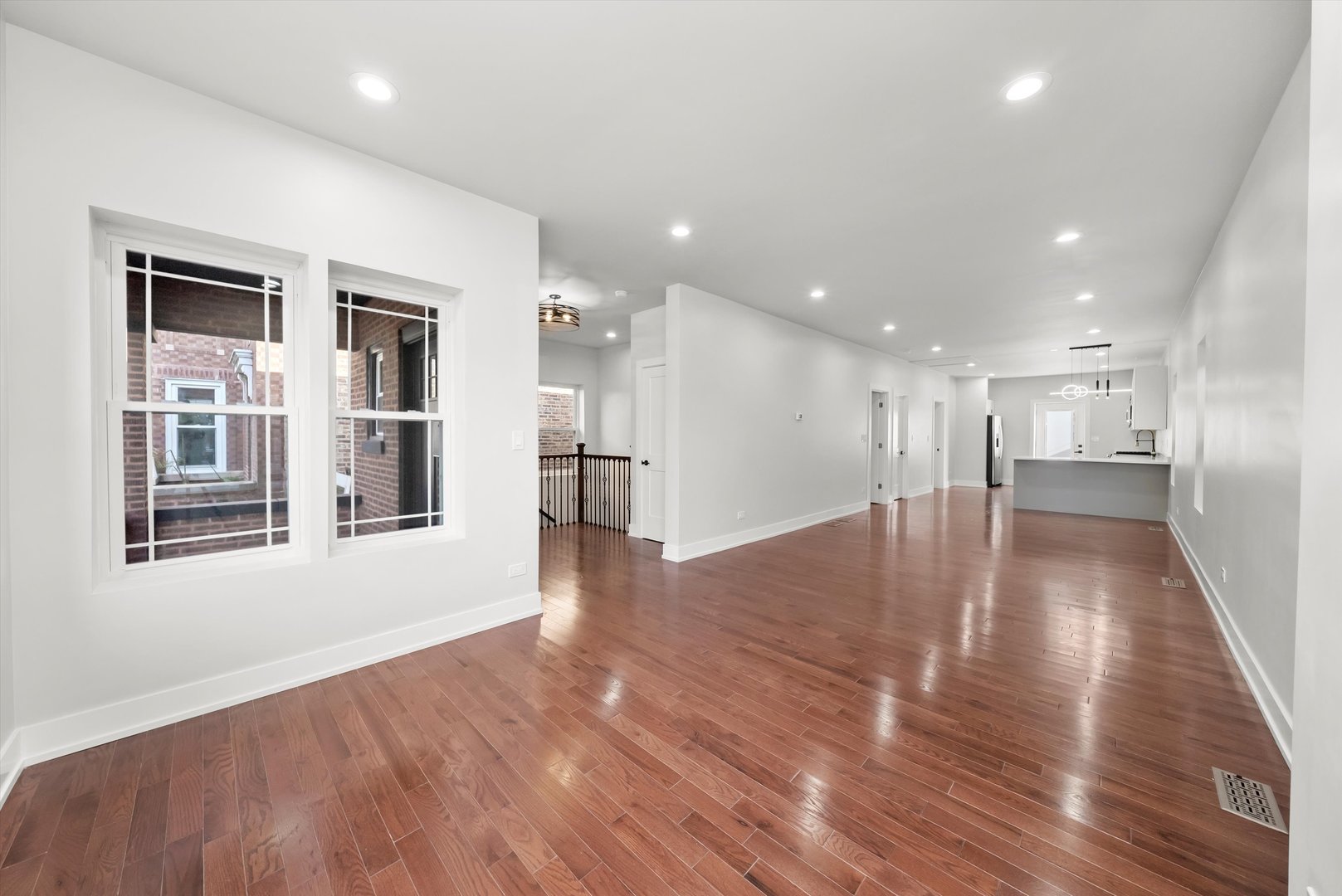 1631 North Parkside Avenue Chicago, IL 60639 - Photo 3 of 33 a view of an empty room with wooden floor and a kitchen