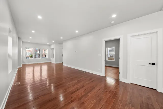 a view of empty room with wooden floor