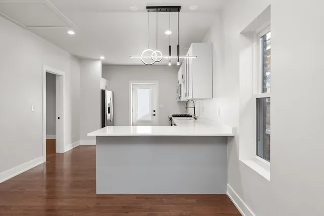 a kitchen with kitchen island a sink appliances and cabinets