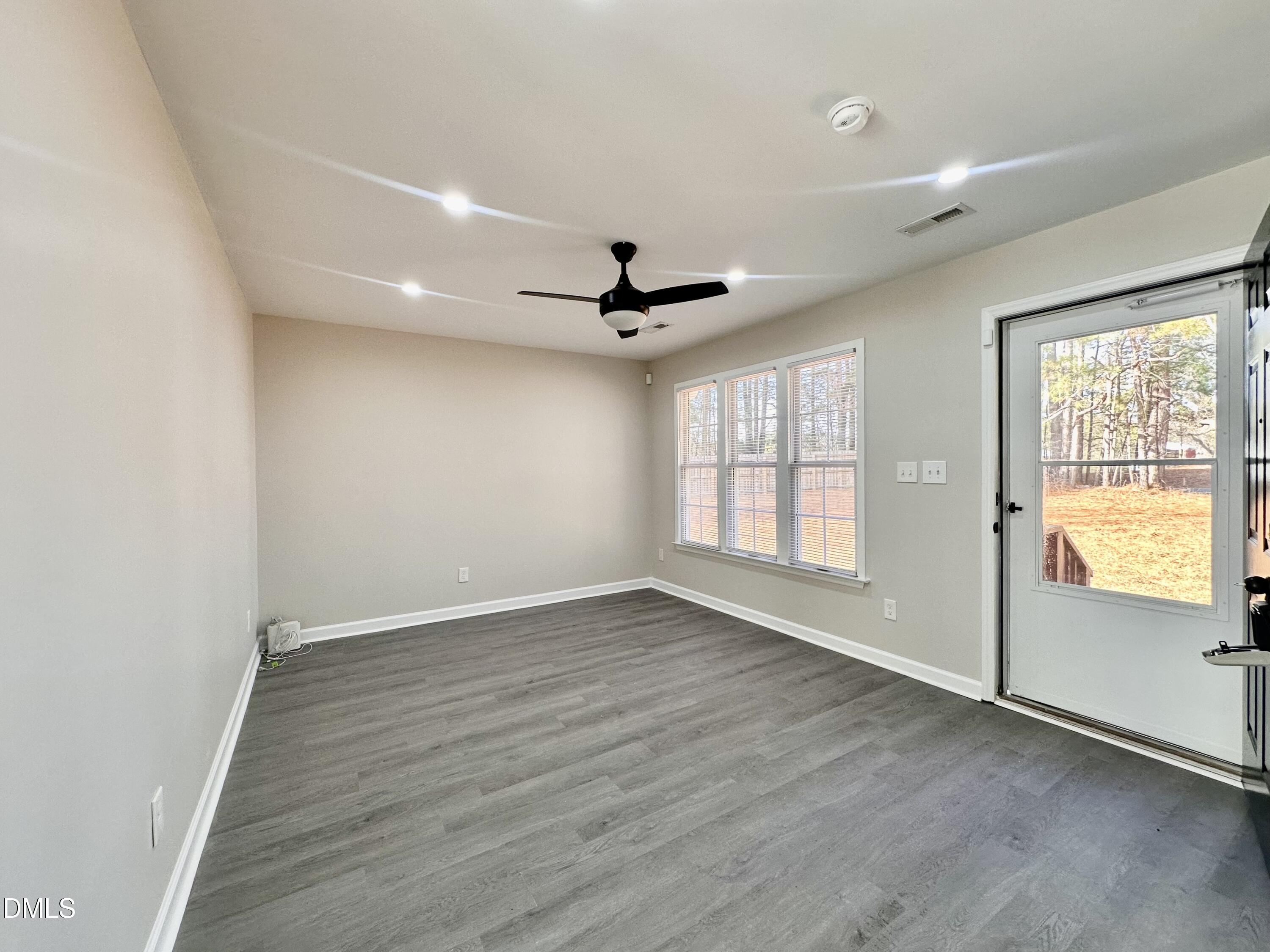 420 Tippett Road Zebulon, NC 27597 - Photo 2 of 14 an empty room with wooden floor and windows