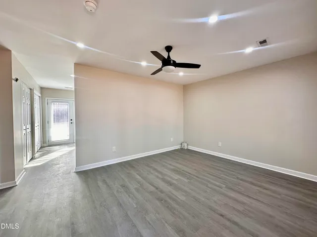 a view of an empty room with wooden floor