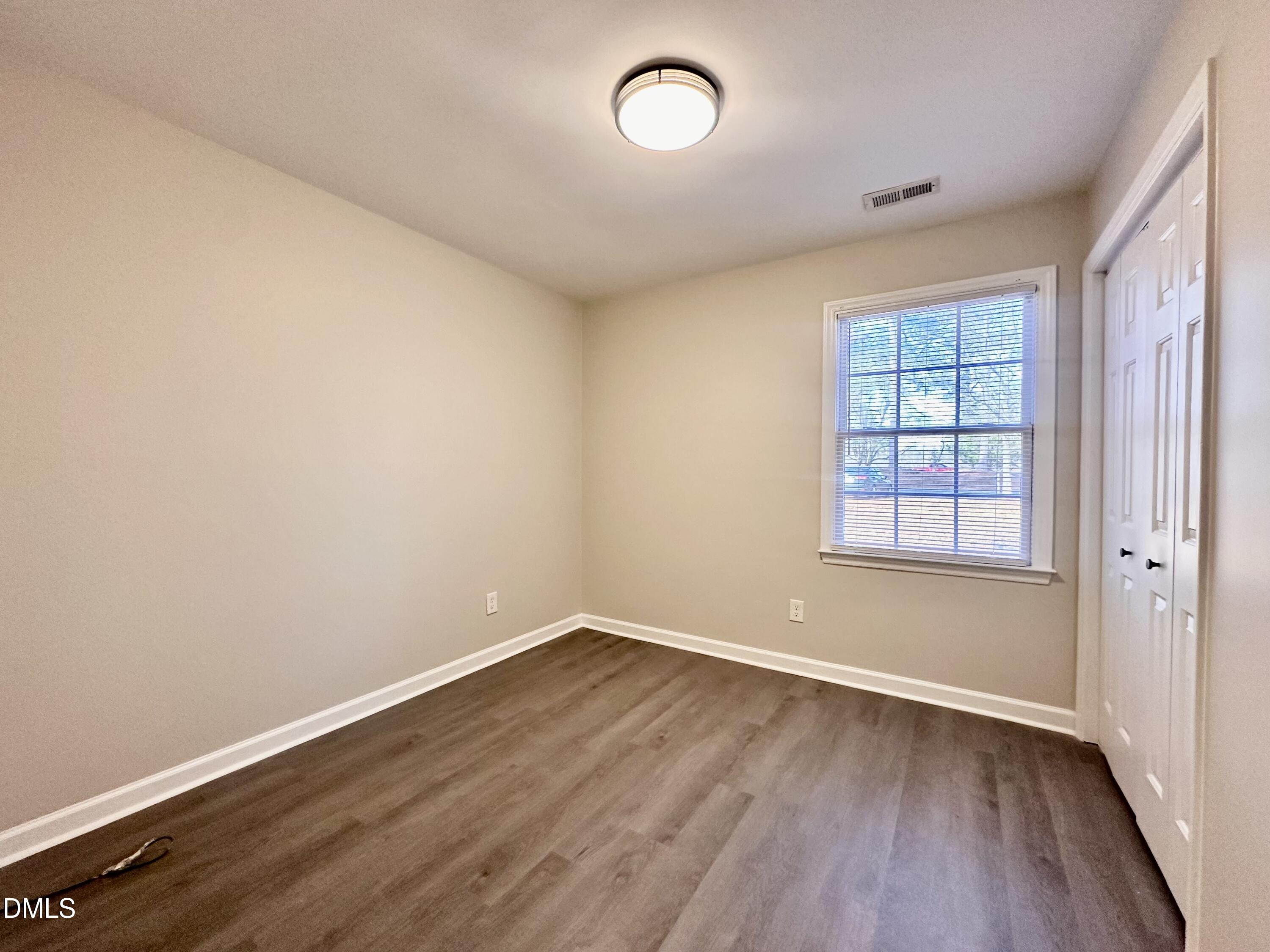 420 Tippett Road Zebulon, NC 27597 - Photo 9 of 14 wooden floor in an empty room with a window