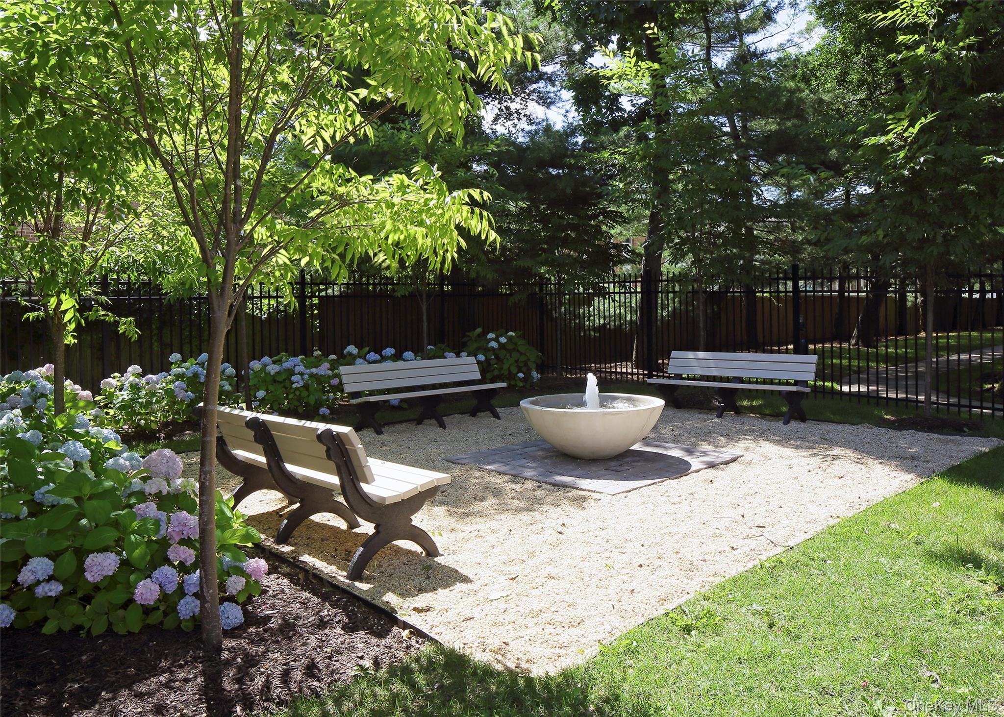 7 Spinning Wheel Road, Unit 1B Massapequa, NY 11758 - Photo 11 of 12 a view of a backyard with sitting area