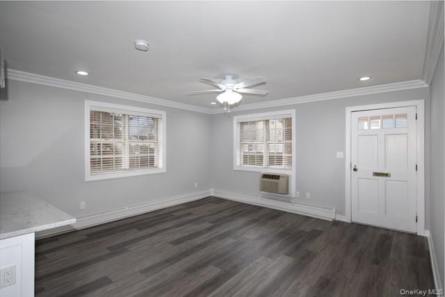 7 Spinning Wheel Road, Unit 1B Massapequa, NY 11758 - Photo 3 of 12 a view of an empty room with wooden floor and a window