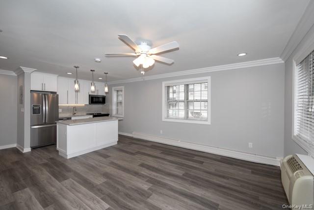 7 Spinning Wheel Road, Unit 1B Massapequa, NY 11758 - Photo 4 of 12 a kitchen with stainless steel appliances kitchen island wooden floor and window