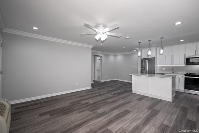 7 Spinning Wheel Road, Unit 1B Massapequa, NY 11758 - Photo 5 of 12 a view of an empty room and kitchen with wooden floor