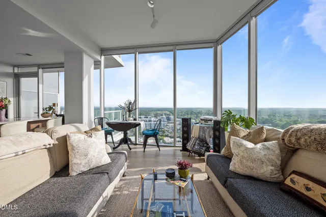 a living room with furniture and floor to ceiling windows