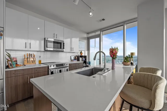 a kitchen with stainless steel appliances granite countertop a sink a stove and a refrigerator