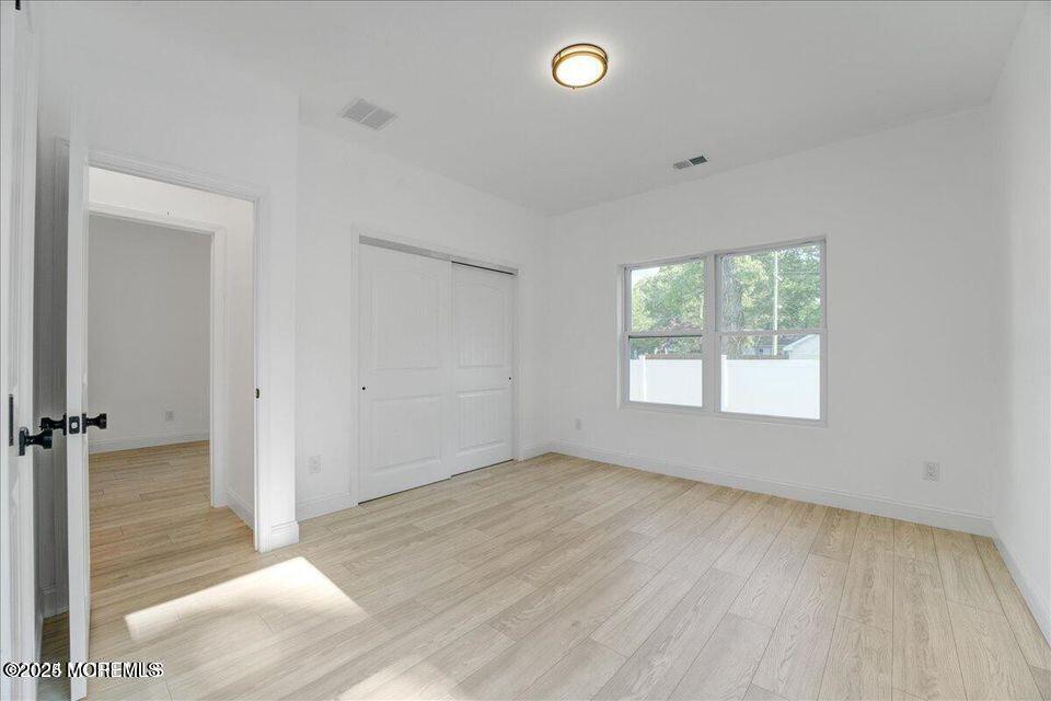 553 Ocean Gate Drive Ocean Gate, NJ 08740 - Photo 7 of 25 an empty room with wooden floor and windows