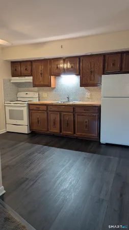 a kitchen with stainless steel appliances wooden cabinets and a wooden floor