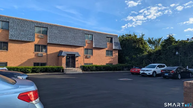 a front view of a house with lots of cars parked on road