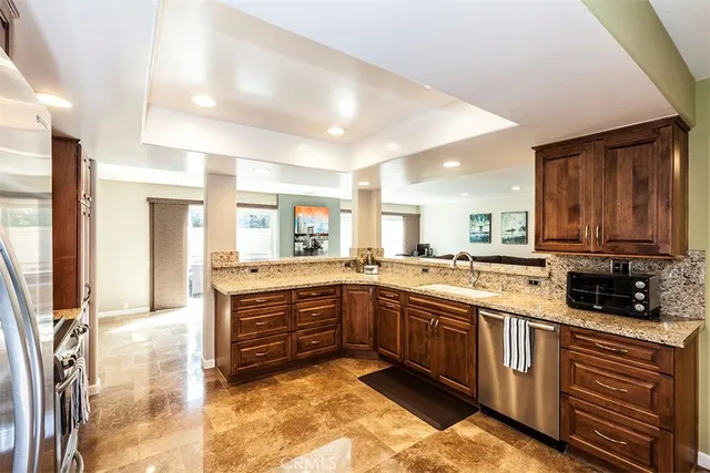 a large kitchen with stainless steel appliances granite countertop a sink and cabinets