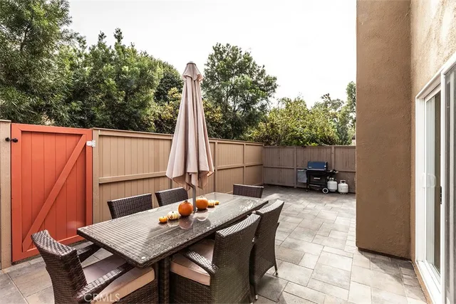 a backyard of a house with barbeque oven table and chairs