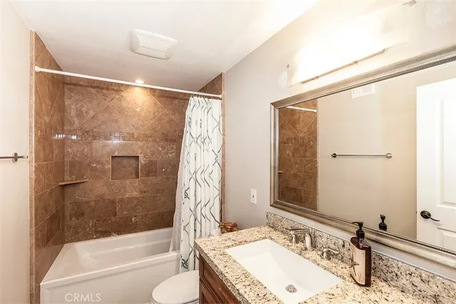 a bathroom with a granite countertop sink toilet and shower