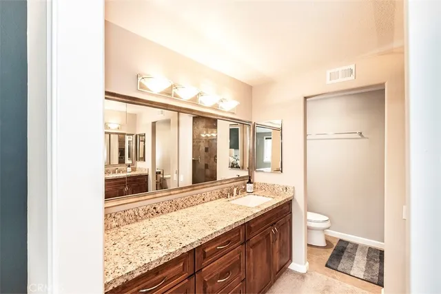 a bathroom with a granite countertop sink toilet and shower