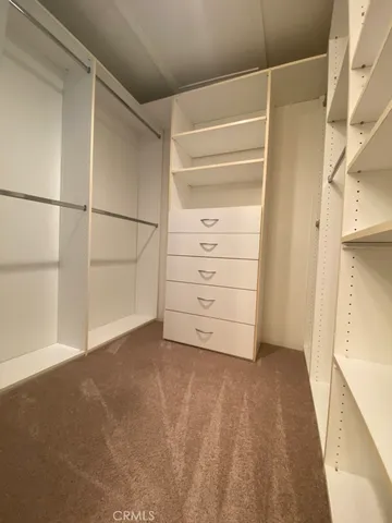 a view of walk in closet with empty racks