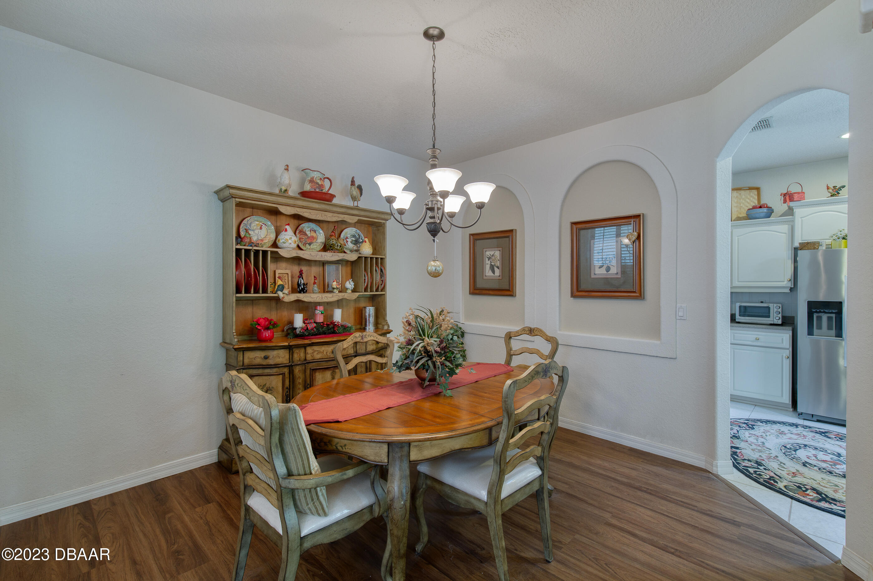 87 Timucuan Drive Ormond Beach, FL 32174 - Photo 12 of 63 a dining room with furniture a chandelier and wooden floor