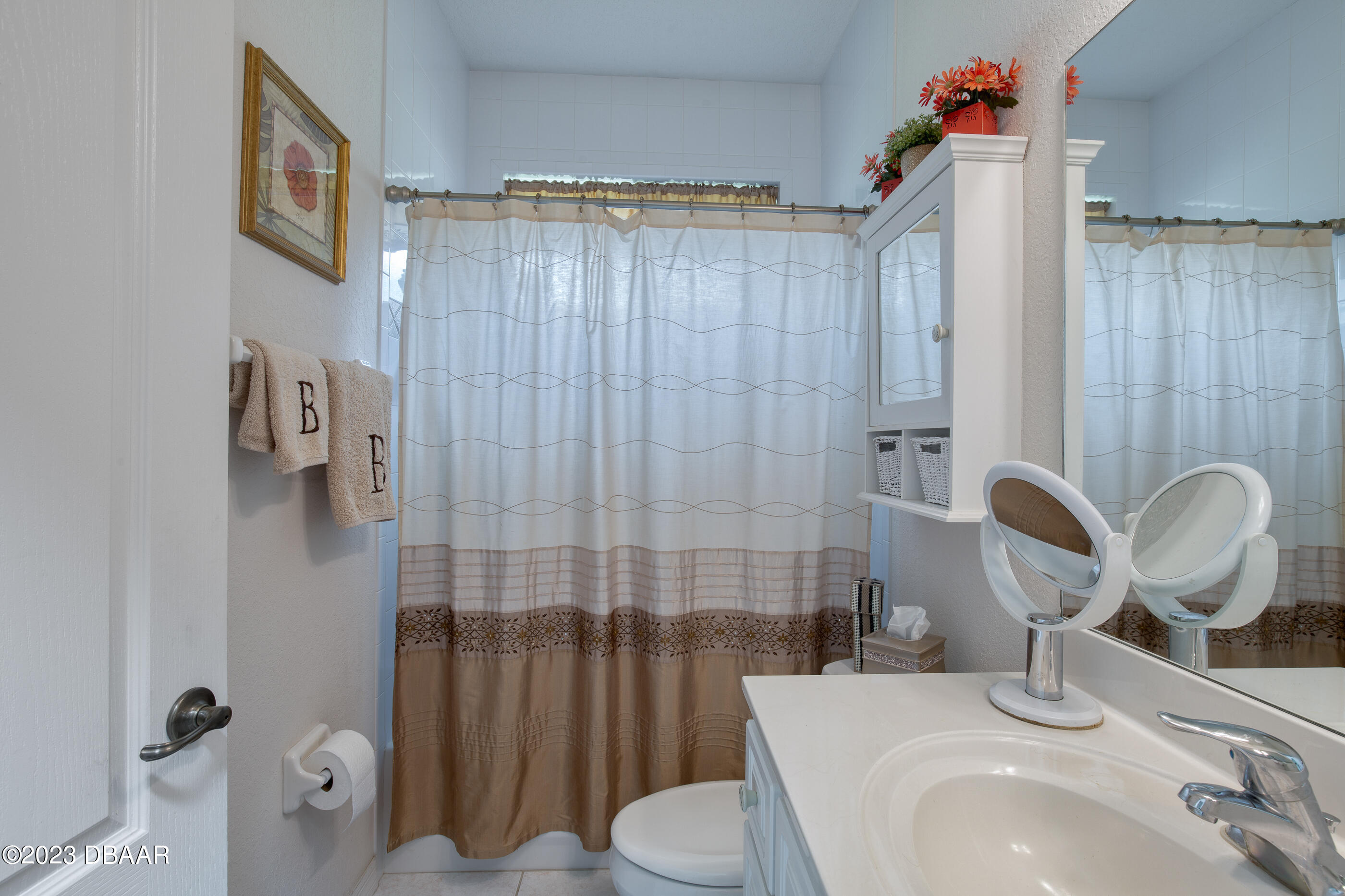 87 Timucuan Drive Ormond Beach, FL 32174 - Photo 31 of 63 a bathroom with a sink a toilet and shower curtain