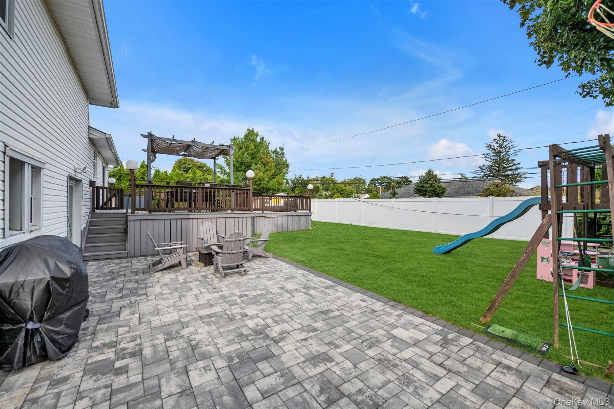 12 Julliard Drive Plainview, NY 11803 - Photo 20 of 23 Fenced backyard with a patio area, a playground, and area for grilling