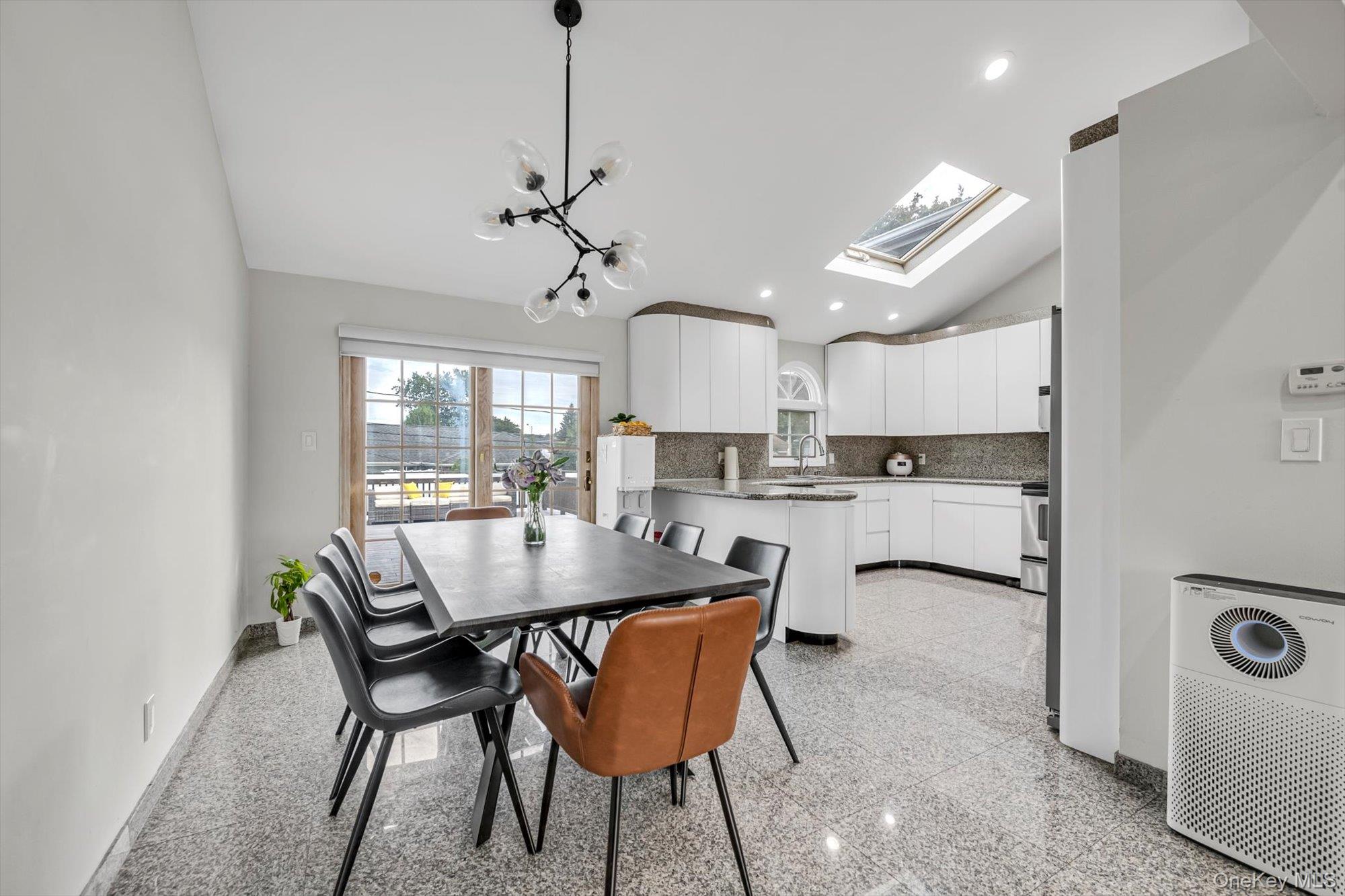 12 Julliard Drive Plainview, NY 11803 - Photo 7 of 23 Dining room with lofted ceiling, granite tiled floors, a skylight, recessed lighting, and a chandelier