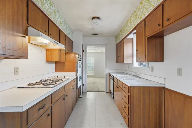 a kitchen with stainless steel appliances granite countertop white cabinets and a stove