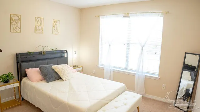 a bed sitting in a bedroom next to a window