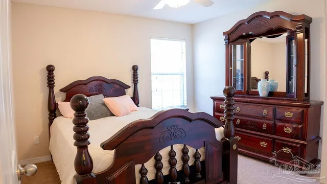 a bedroom with a bed and a mirror on the dresser