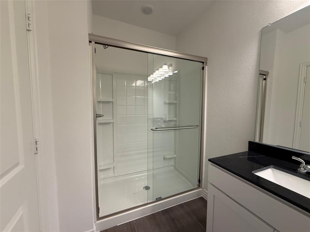 412 East 7th Street, Unit 2 Bonham, TX 75418 - Photo 12 of 20 a bathroom with a granite countertop sink mirror and shower