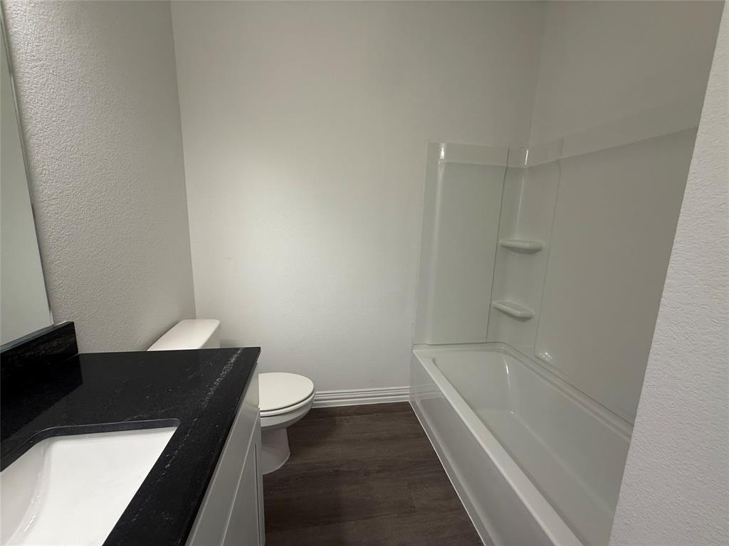412 East 7th Street, Unit 2 Bonham, TX 75418 - Photo 15 of 20 a bathroom with a bathtub and a toilet